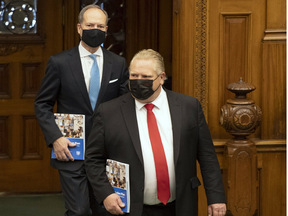 Ontario Finance Minister Peter Bethlenfalvy (back) arrives in the Ontario legislature in Toronto with Premier Doug Ford ( front) to deliver the provincial budget on  March 24, 2021.