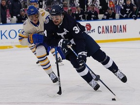 Mar 13, 2022; Hamilton, Ontario, CAN; Toronto Maple Leafs forward Auston Matthews (34) carries the puck past Buffalo Sabres forward Tage Thompson (72) during the third period in the 2022 Heritage Classic ice hockey game at Tim Hortons Field.