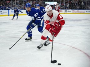 Detroit Red Wings forward Lucas Raymond controls the puck against Toronto Maple Leafs defenseman Timothy Liljegren during the second seriod at Scotiabank Arena.