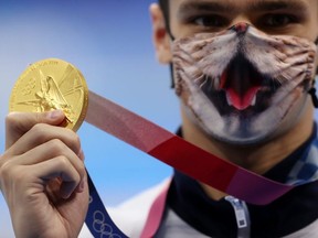 Tokyo 2020 Olympics - Swimming - Men's 200m Backstroke - Medal Ceremony - Tokyo Aquatics Centre - Tokyo, Japan - July 30, 2021. Evgeny Rylov of the Russian Olympic Committee wearing a face mask poses with the gold medal.