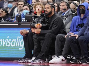Drake and his son Adonis sit courtside at the Toronto Raptors game.