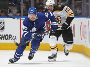 Ilya Lyubushkin of the Toronto Maple Leafs chases after a puck against Craig Smith of the Boston Bruins during an NHL game at Scotiabank Arena on April 29, 2022 in Toronto, Ontario, Canada.