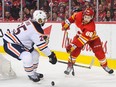Andrew Mangiapane  of the Calgary Flames fights for the puck against Darnell Nurse  of the Edmonton Oilers during the third period of Game One of the Second Round of the 2022 Stanley Cup Playoffs at Scotiabank Saddledome on May 18, 2022 in Calgary, Alberta, Canada.