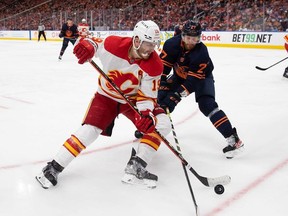 Matthew Tkachuk of the Calgary Flames battles against Brett Kulak of the Edmonton Oilers during the third period in Game Four of the Second Round of the 2022 Stanley Cup Playoffs at Rogers Place on May 24, 2022 in Edmonton, Canada.