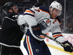 Connor McDavid of the Edmonton Oilers fends off Matt Roy of the Los Angeles Kings during a 3-2 Oilers win at Crypto.com Arena on April 07, 2022 in Los Angeles, California.