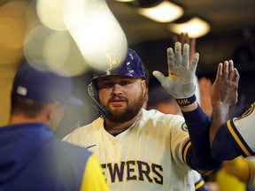 Rowdy Tellez #11 of the Milwaukee Brewers is congratulated by teammates following a two run home run against the Cincinnati Reds during the sixth inning at American Family Field on May 4, 2022 in Milwaukee, Wisconsin.