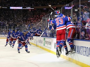 The New York Rangers celebrate their 4-3 victory over the Pittsburgh Penguins in Game 7 of their first-round Stanley Cup playoff series in New York on Sunday, May 15, 2022.