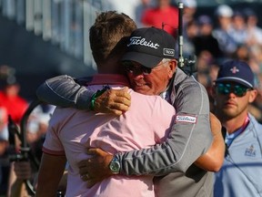 Justin Thomas of the United States reacts to his winning putt on the 18th green, the third playoff hole, with his father Mike Thomas, during the final round of the 2022 PGA Championship at Southern Hills Country Club on May 22, 2022 in Tulsa, Oklahoma.