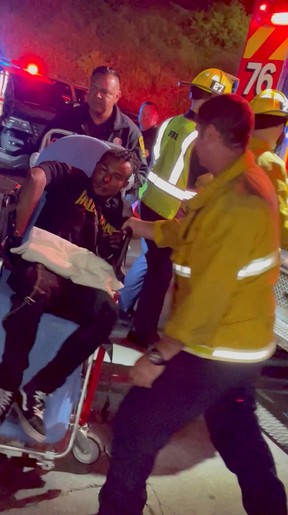 A man is transported into an ambulance after comedian Dave Chappelle was attacked on stage during stand-up Netflix show at the Hollywood Bowl, in Los Angeles, U.S., May 3, 2022, in this still image obtained from a social media video. Theodore Nwajei/via REUTERS