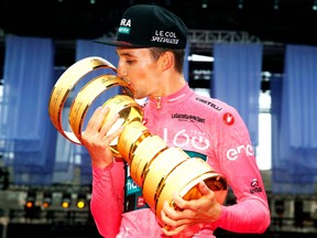 Team Bora's Australian rider Jai Hindley celebrates kisses the "Trofeo Senza Fine" race winner's trophy on the podium after winning the Giro dItalia 2022 cycling race, following the last stage, a 17.4 km individual time trial in Verona on May 29, 2022. (Photo by Luca Bettini / AFP)