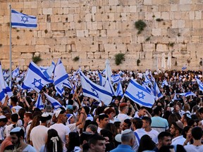 Demonstrators gather with Israeli flags at the Western Wall in the old city of Jerusalem on May 29, 2022, during the Israeli 'flags march' to mark "Jerusalem Day". (Photo by GIL COHEN-MAGEN/AFP via Getty Images)
