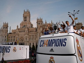 Real Madrid players celebrate with their trophy as they wave from an open-top bus during a parade through the streets of Madrid on May 29, 2022, a day after beating Liverpool in the UEFA Champions League final in Paris.  (Photo by GABRIEL BOUYS/AFP via Getty Images)