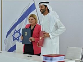 A handout picture obtained from the Israeli Government Press Office (GPO) on May 31, 2022, shows (L to R) the economy ministers of Israel and the UAE Orna Barbivai and Abdulla bin Touq al-Marri posing for a photo during a signing ceremony for a free trade deal between Israel and the UAE, in Dubai.