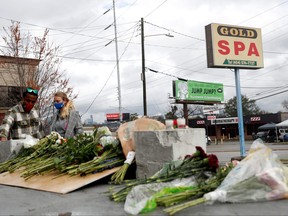 Anthony Roberts, 33, and Olivia Roberts, 28, lay flowers at a makeshift memorial outside Gold Spa following the deadly shootings in Atlanta, Ga., March 18, 2021.