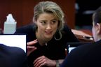 Amber Heard speaks to her legal team during the Depp vs Heard defamation trial in Fairfax, Va., April 28, 2022. 