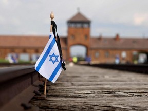 A small national flag of Israel has been placed on the rail tracks at the site of the former Auschwitz-Birkenau camp during commemorations to honour the victims of the Holocaust, near the village of Brzezinka, Poland, April 28, 2022.