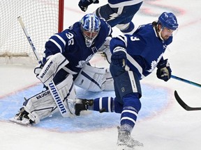 Leafs goalie Jack Campbell  makes a save as the puck bounces past defenceman Justin Holl last night.  USA TODAY Sports