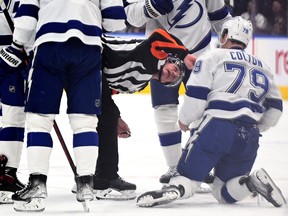 Tampa Bay Lightning forward Ross Colton (79) is examined by referee Dan O'Rourke (9) after being injured from a hit by Toronto Maple Leafs forward Kyle Clifford (not shown) in game one of the first round of the 2022 Stanley Cup Playoffs at Scotiabank Arena.