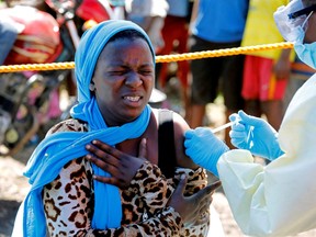 A young woman reacts as a health worker injects her with the Ebola vaccine, in Goma, Democratic Republic of Congo, August 5, 2019.