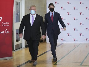 Prime Minister Justin Trudeau, right, and Ontario Premier Doug Ford walk together after reaching and agreement in $10-a-day child-care program deal in Brampton, Ont., on Monday, March 28, 2022.