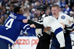 Officials separate Toronto Maple Leafs forward Wayne Simmonds (24) and Tampa Bay Lightning forward Corey Perry (10) during the third period, first round of an NHL Stanley Cup hockey playoff game in Toronto, Monday, May 2, 2022 of the year.