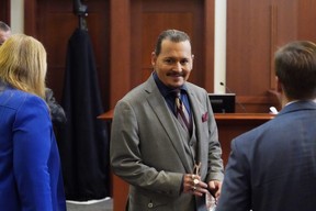 Johnny Depp smiles towards the courtroom gallery in the courtroom as he waits for his trial to begin after a break at the Fairfax County Circuit Courthouse in Fairfax, Va., Monday, May 16, 2022.