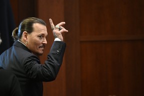 Johnny Depp makes a gesture on Tuesday, May 17, 2022, when he leaves the court during a break at the Fairfax County Circuit Court in Fairfax, Virginia.