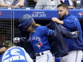 Blue Jays starting pitcher Alek Manoah  puts the home run jacket on teammate Bo Bichette after his solo homer during fourth inning MLB interleague baseball action against the Cincinnati Reds, in Toronto, Saturday, May 21, 2022