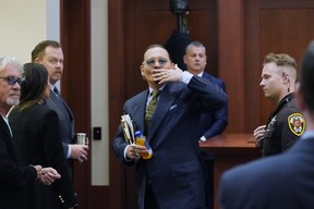 Johnny Depp gestures to the gallery as he leaves for a break in the courtroom at the Fairfax County Circuit Courthouse in Fairfax, Va., Monday, May 23, 2022.