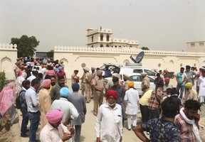 Villagers gather outside the residence of Shubhdeep Singh Sidhu, also known around the world by his stage name Sidhu Moose Wala, in Musa village, near in Mansa, Punjab state, India, Monday, May 30, 2022. (AP Photo)