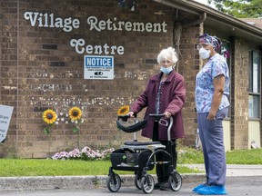 A resident and a worker watch as 150 nursing union members show support at rchard Villa Long-Term Care in Pickering, Ont. on Monday June 1, 2020.
