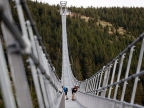 People stand on the newly-built world's longest suspension bridge a day before its official opening in the mountain resort of Dolni Morava, Czech Republic, May 12, 2022.