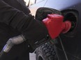 A driver pumps premium gas into her car at a gas station in Toronto on March 3, 2022.