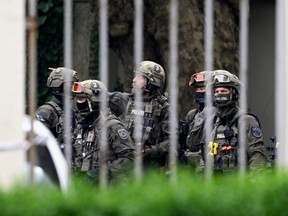 Special police officers stand guard near a building after shots were fired at a German school in Bremerhaven, Germany, Thursday, May 19, 2022.