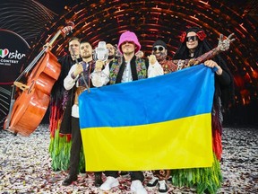 Members of the band "Kalush Orchestra" pose onstage with the winner's trophy and Ukraine's flags after winning on behalf of Ukraine the Eurovision Song contest 2022 on May 14, 2022 at the Pala Alpitour venue in Turin. (Photo by MARCO BERTORELLO/AFP via Getty Images)