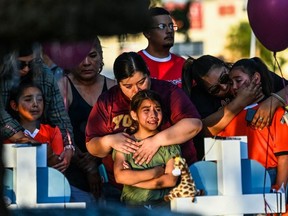 Gabriella Uriegas, a soccer teammate of Tess Mata who died in the shooting, cries while her mother Geneva Uriegas holds her as they visit a makeshift memorial outside the Uvalde County Courthouse in Texas on May 26, 2022. (Photo by CHANDAN KHANNA / AFP) (Photo by CHANDAN KHANNA/AFP via Getty Images)