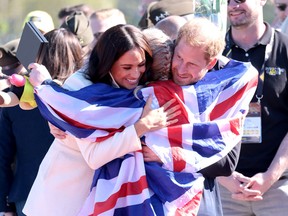 Prince Harry, Duke of Sussex and Meghan, Duchess of Sussex hug Lisa Johnston of Team United Kingdom at the Athletics Competition during day two of the Invictus Games The Hague 2020 at Zuiderpark on April 17, 2022 in The Hague, Netherlands. (Photo by Chris Jackson/Getty Images for the Invictus Games Foundation)