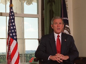 U.S. President George W. Bush poses for photographers in the White House in Washington, DC, after announcing that U.S. Armed Forces have begun a bombing campaign of Afghanistan in October, 2001.