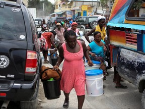 People carry belongings as they flee their homes due to ongoing gun battles between rival gangs, in Port-Au-Prince, Haiti April 28, 2022.