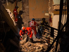 Firefighters and rescue workers remove debris from the ruins of the Saratoga Hotel, in Havana, on May 8, 2022.