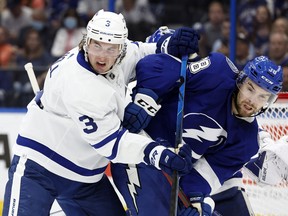 Toronto Maple Leafs defenseman Justin Holl and Toronto Maple Leafs defenseman Rasmus Sandin  fight to control the puck during the second period at Amalie Arena.