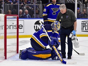 St. Louis Blues goaltender Jordan Binnington (50) is helped off the ice by a trainer after a collision against the Colorado Avalanche at Enterprise Center.