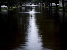 A woman walks down a flooded road during the aftermath of Hurricane Harvey on Aug. 30, 2017 in Houston, Texas.