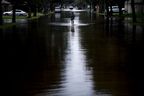 Une femme marche sur une route inondée à la suite de l'ouragan Harvey le 30 août 2017 à Houston, au Texas.