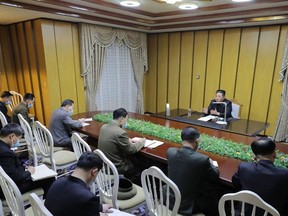 This picture taken Thursday, May 12, 2022 and released from North Korea's official Korean Central News Agency on May 13 shows North Korean leader Kim Jong Un (right) inspecting the National Emergency Quarantine Command at an undisclosed location in North Korea.