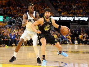 Klay Thompson of the Golden State Warriors drives past Reggie Bullock of the Dallas Mavericks during the third quarter in Game 5 of the 2022 NBA Playoffs Western Conference Finals at Chase Center on May 26, 2022 in San Francisco, Calif.