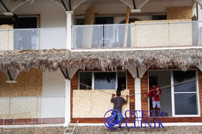 Men board up windows as they prepare for the arrival of Hurricane Agatha, in Puerto Escondido, Oaxaca state, Mexico, May 29, 2022. REUTERS/Jose de Jesus Cortes