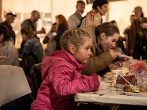 Ein Mädchen isst in einem Empfangszelt, nachdem es am 3. Mai 2022 in Zaporizhzhia, Ukraine, an einem Evakuierungspunkt für Menschen angekommen ist, die aus dem Azovstal-Werk, Mariupol, Melitopol und den umliegenden Städten unter russischer Kontrolle fliehen.