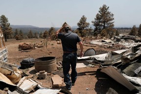 Michael Salazar walks at his property burned during the Hermits Peak and Calf Canyon fires, in Tierra Monte, New Mexico, Wednesday, May 11, 2022.