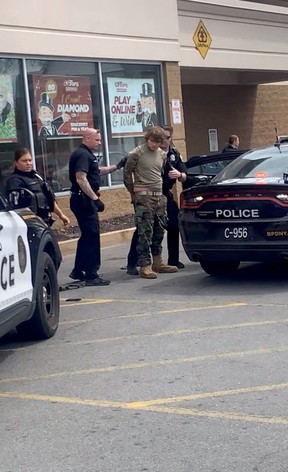 A man is detained following a mass shooting in the parking lot of TOPS supermarket, in a still image from a social media video in Buffalo, N.Y., May 14, 2022.